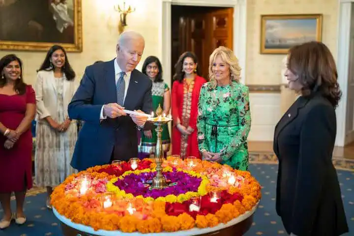 Diplomatic gathering with participants around a Diwali-style lamp and floral arrangement, symbolizing peace, inclusion, and cooperation.